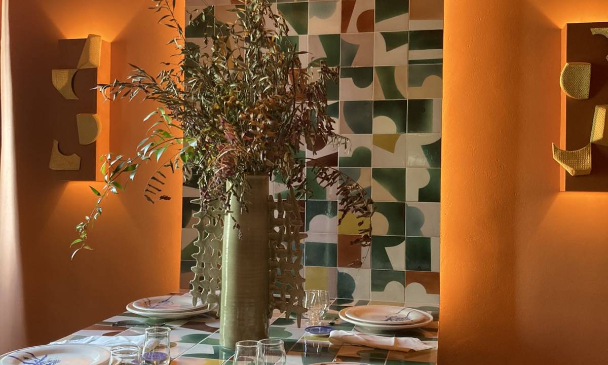 Insight_Casa Decor_Lugar de reunión en comedor con vegetación, vajilla, tonos naranjas y estampados verdes y blancos con ambiente calido