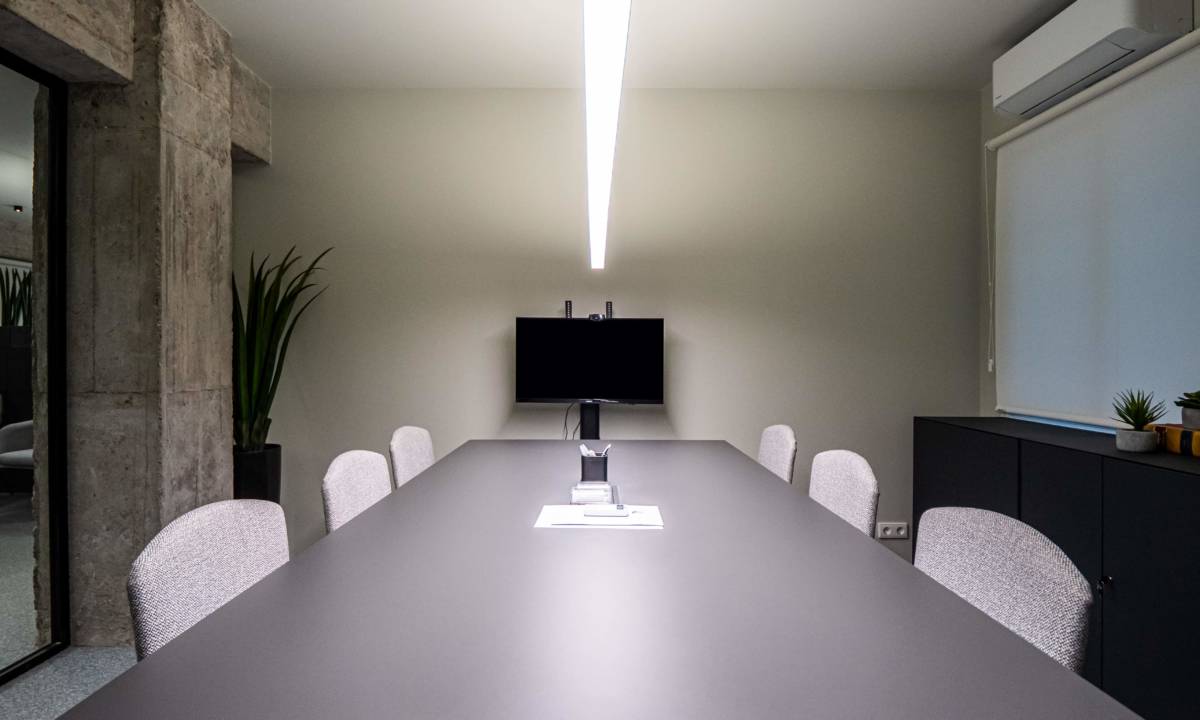 Insight_Post Colaboración_Sala de reuniones en tonos grises y negros con pantalla para videollamadas y reuniones de empleados