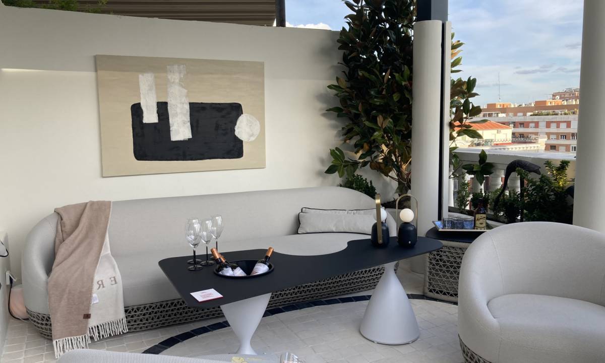 Insight_Casa Decor_Terraza exterior en azotea de edificio con mobiliario blanco, negro y gris, sofa, mesa, cuadro y estancia natural