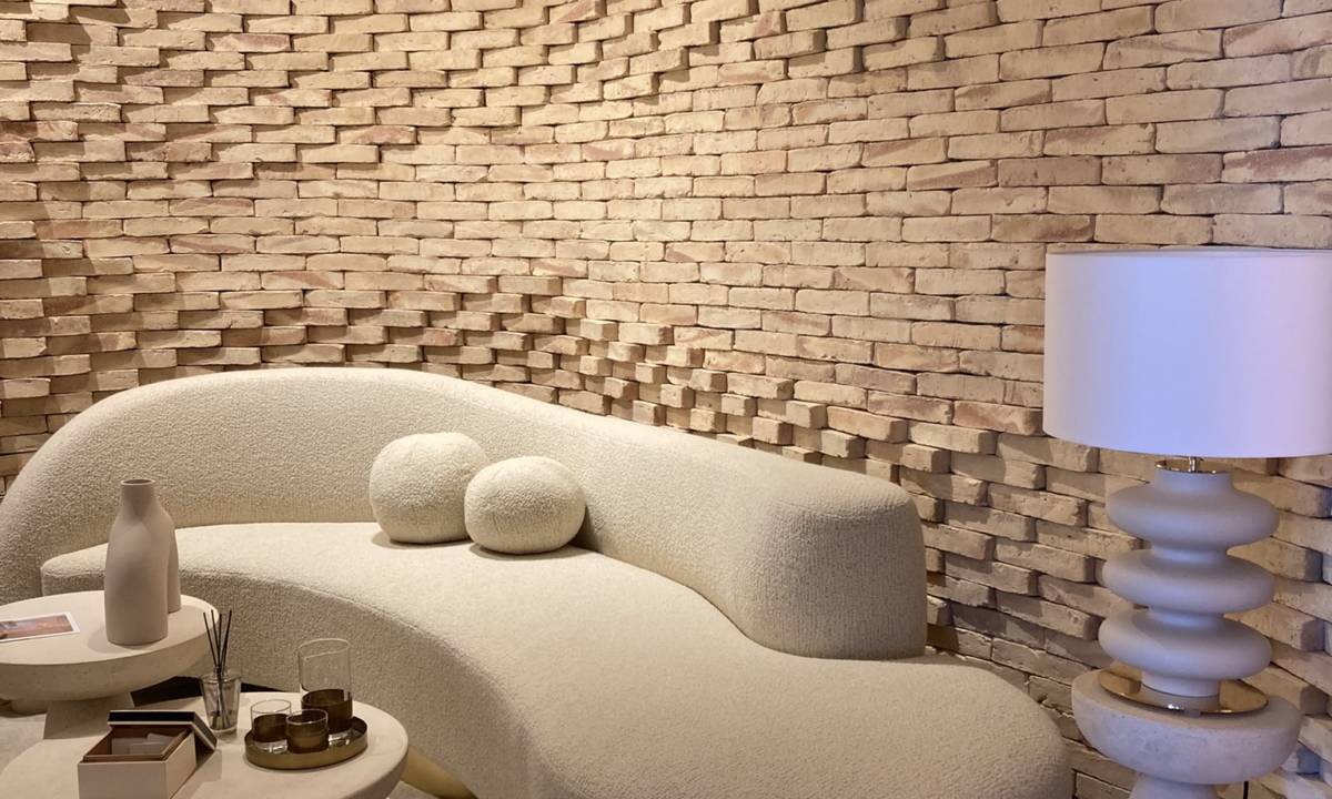 Insight_Casa Decor_Espacio natural con sofá en tonos arena y tierra, pared con textura, luminaria blanca y complementos de sala de estar con tonos naturales y beige