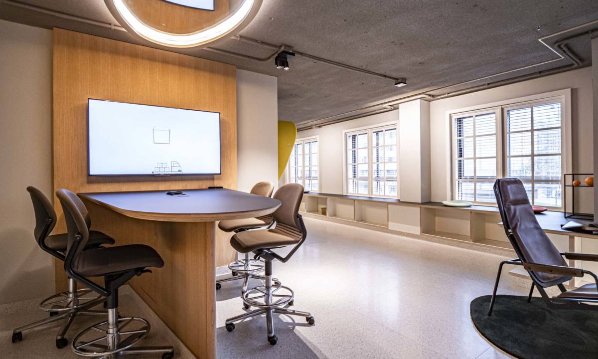 Insight_Post Colaboración_Espacio colaborativo en oficina con taburetes altos, mesa de madera y tecnologia