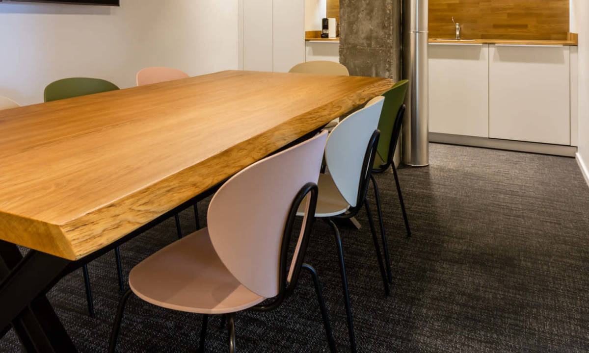 Mesa de zona de office con sillas de colores y detalles en madera