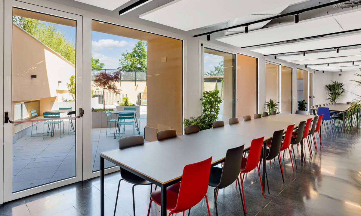 Espacio común de residencia de estudiantes en entorno coliving con mobiliario de sala de reuniones