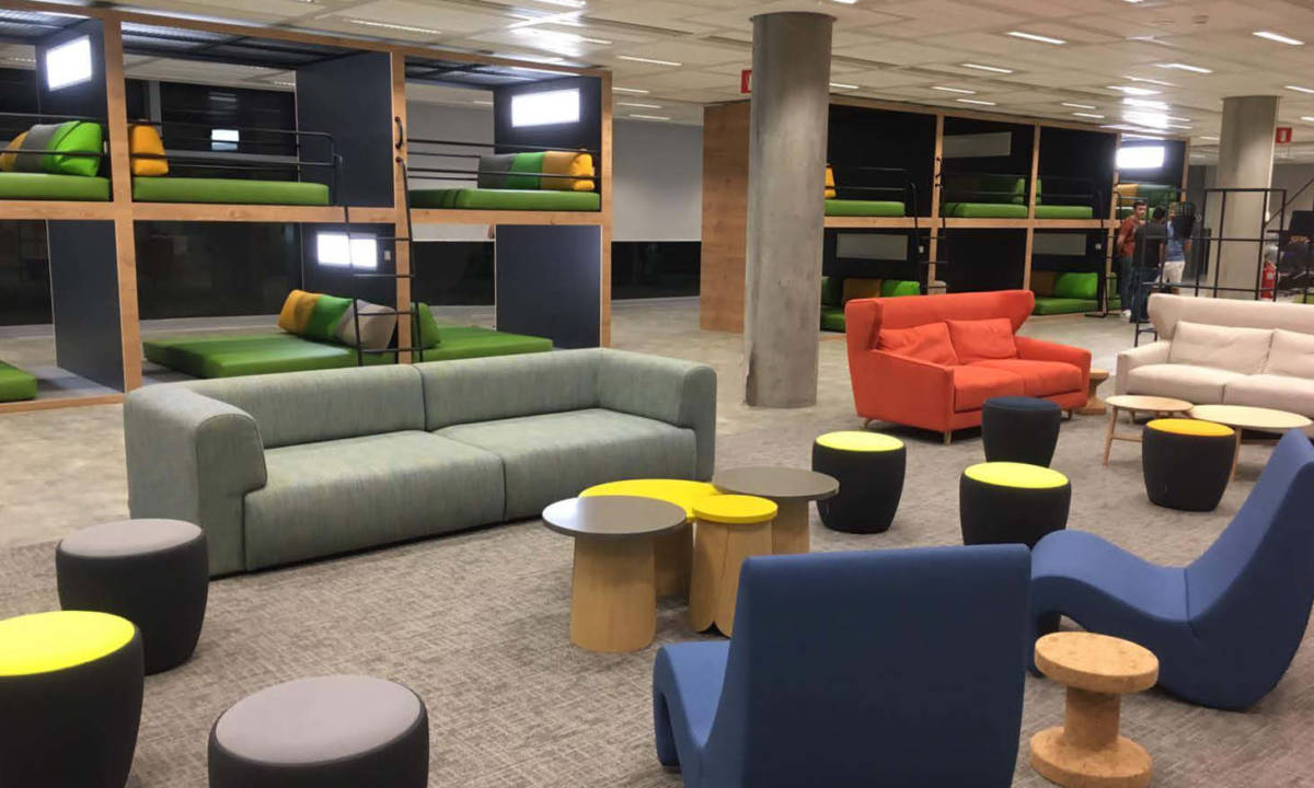 Espacio de descanso común en edificio de oficinas con mobiliario moderno de colores