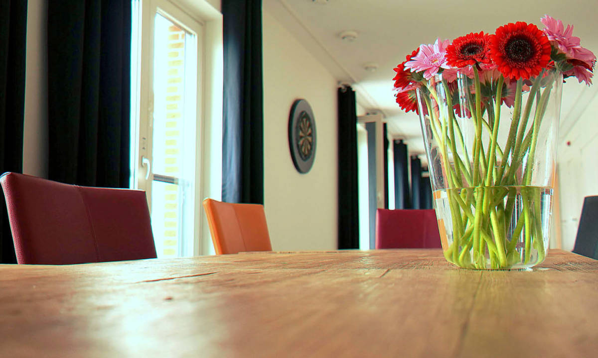 Mesa de trabajo con flores encima de mobiliario