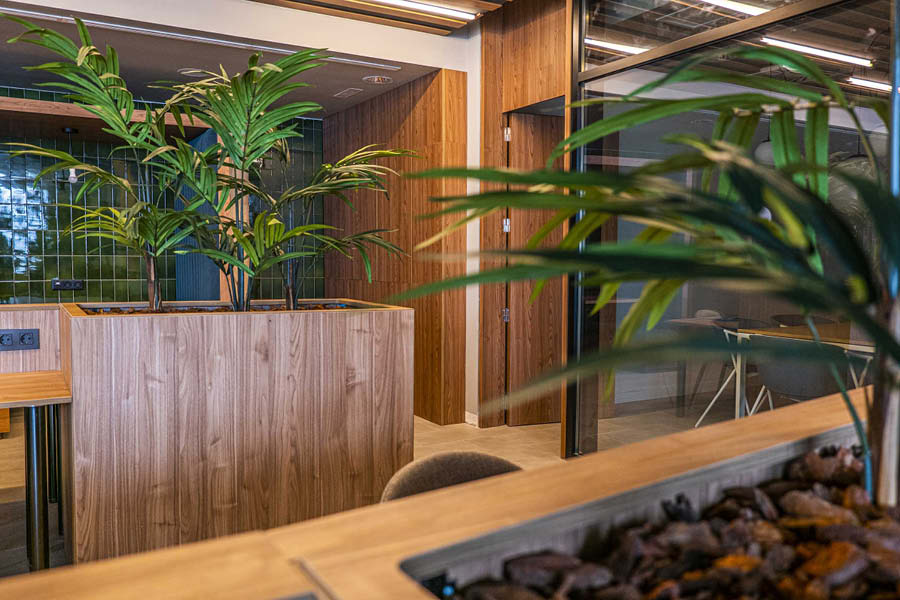 Espacio de coworking con jardines interiores y materiales naturales