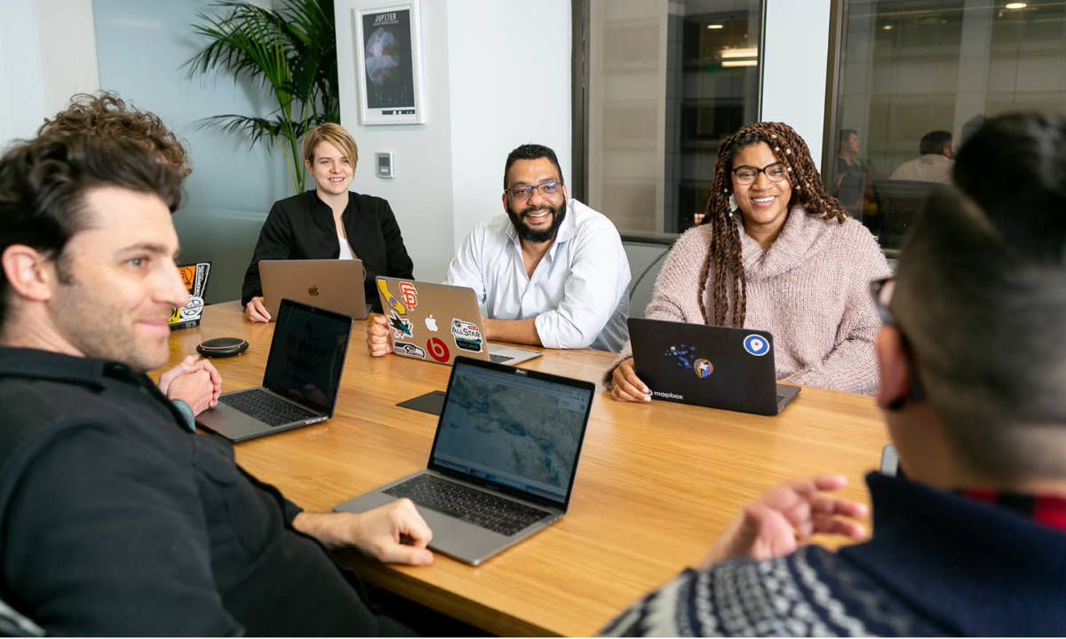 empleados sentados con portátiles en una reunión