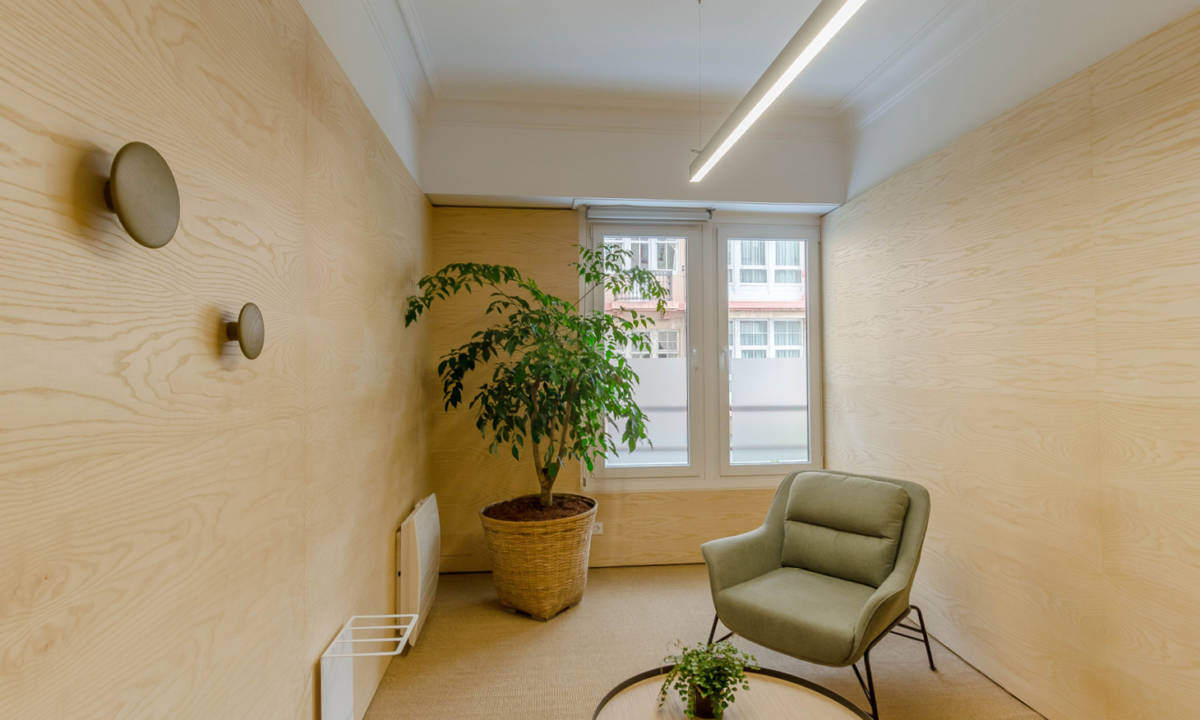 sala de espera con mobiliario y vegetación en clínica