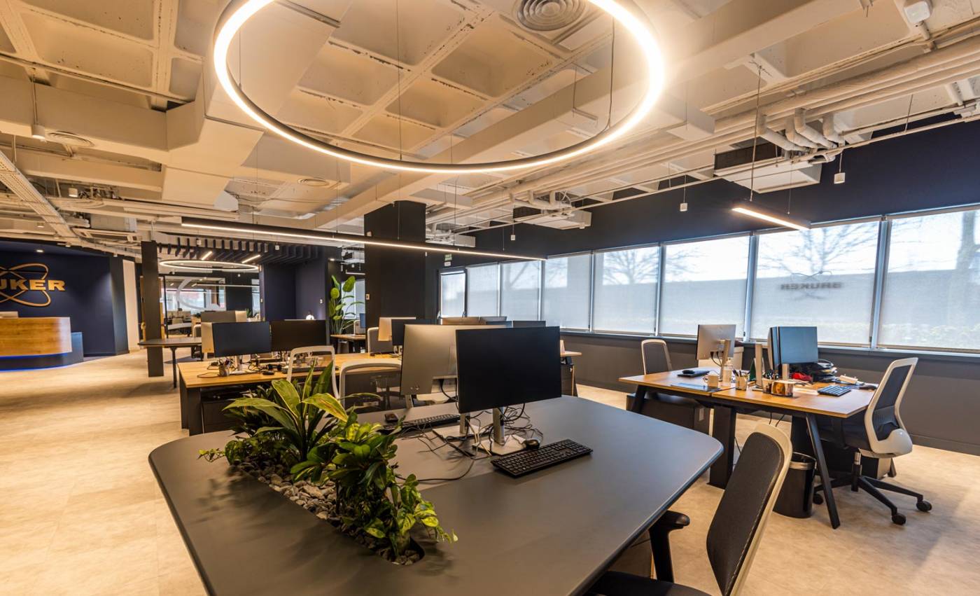 Amplio espacio de oficina con iluminación natural y artificial sobre los puestos de trabajo