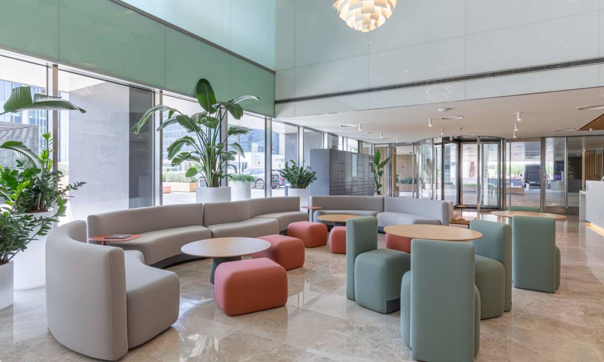 Sofás y mobiliario de oficina para renovación de espacio de trabajo en Madrid, en tonos verdes, gris y rojos