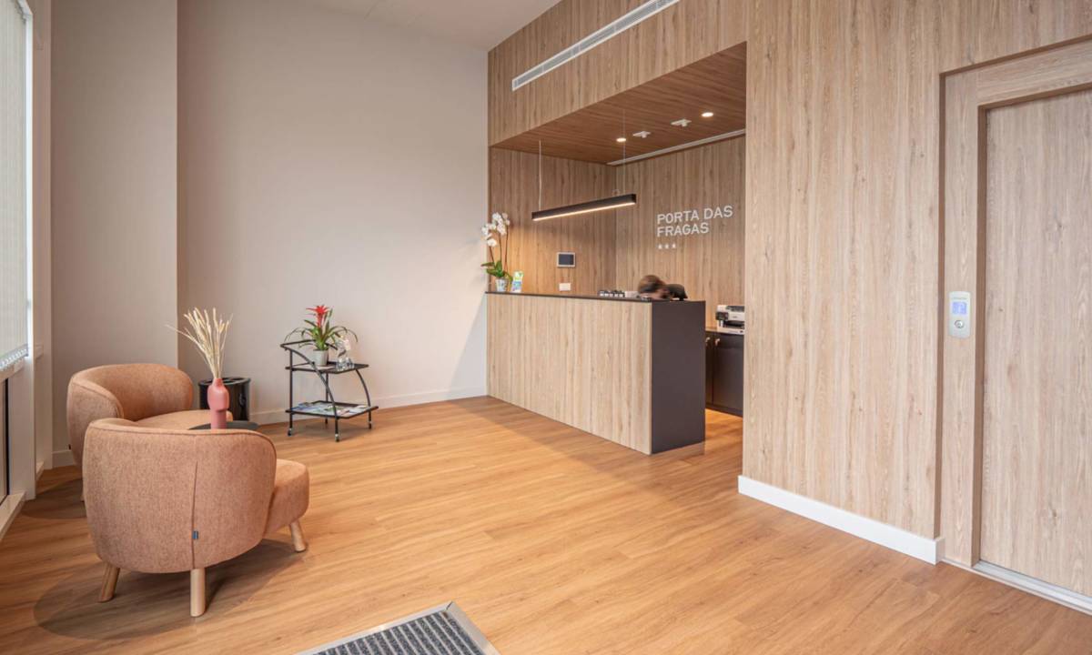 Recepción con carpintería de madera a medida, butacas color teja y demás mobiliario de hall de entrada