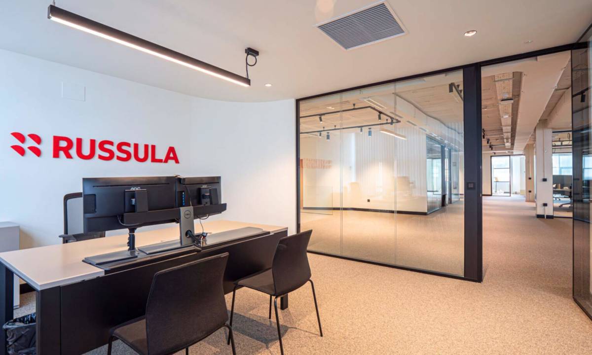 Despacho de dirección con mesa, sillas, mampara y equipamiento audiovisual