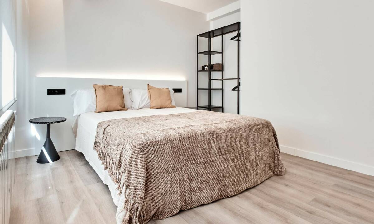 Dormitorio doble en apartamentos compartidos con cama, textiles y mobiliario, cabecero a medida