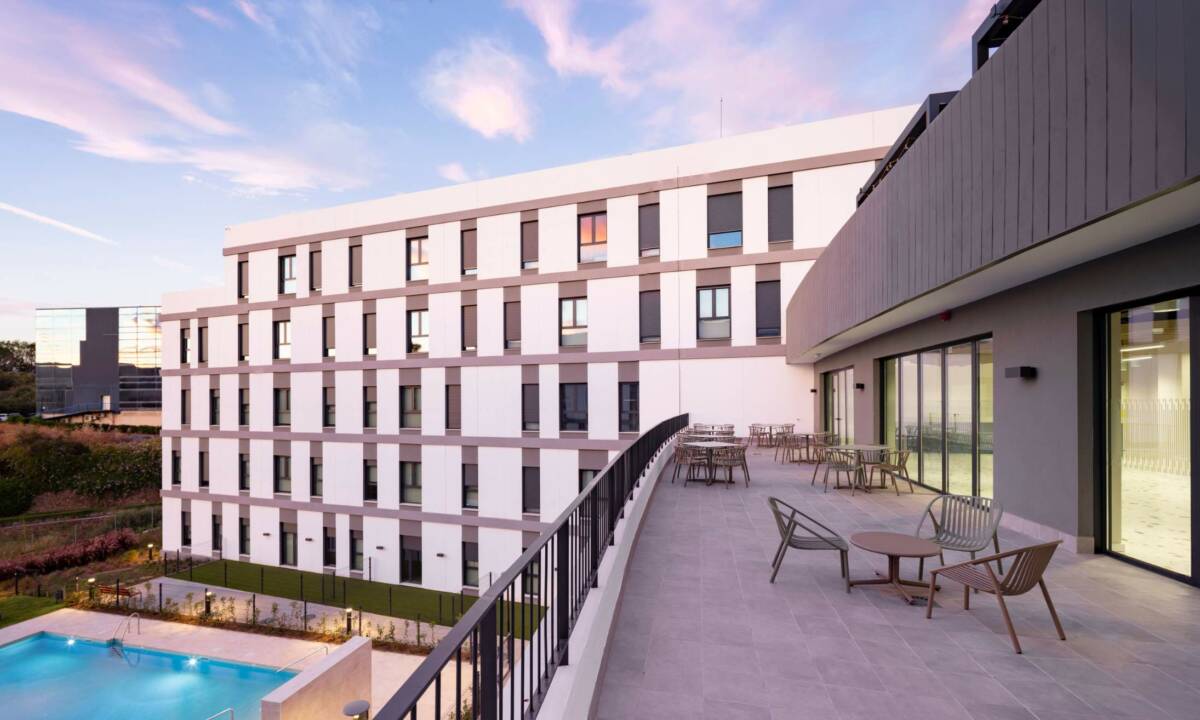 Zona exterior de espacio Coliving con piscina y mobiliario de exterior