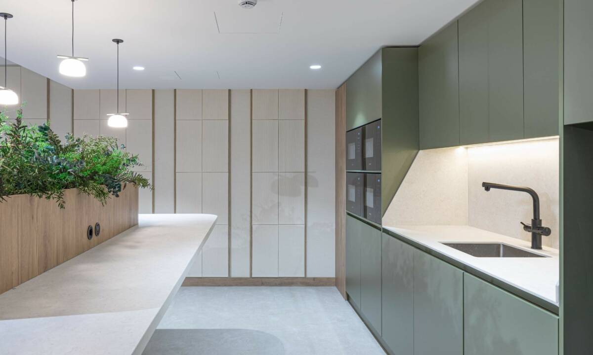 Cocina común con mobiliario a medida y revestimiento de pared con madera