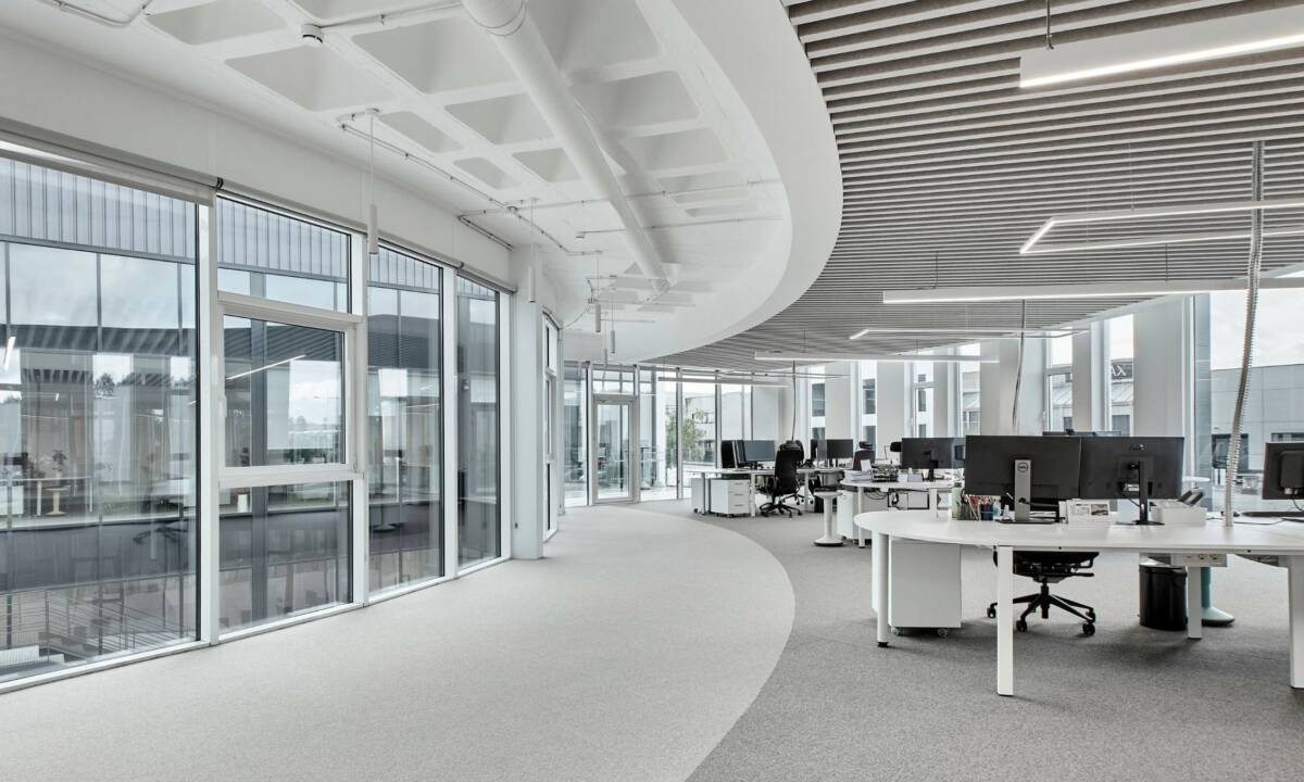 Zona de trabajo con luz natural y puestos operativos en oficina en Galicia