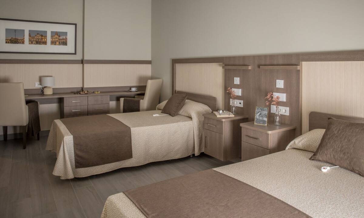 Dormitorio doble con textiles color marrón en residencia de mayores