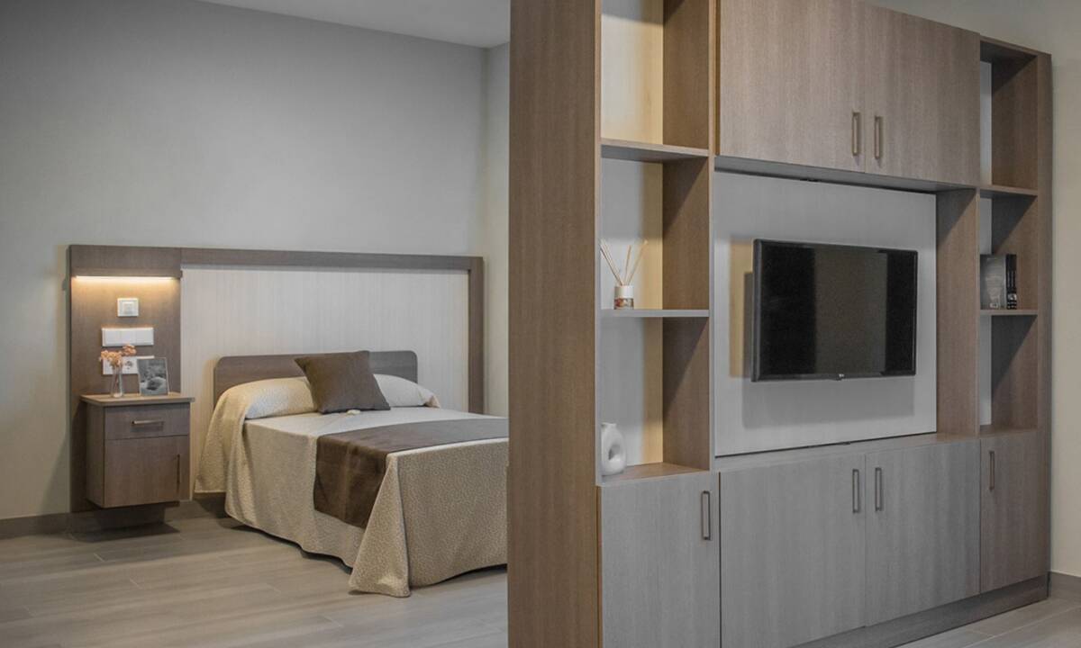 Mueble de carpintería a medida separador de ambiente en habitación con monitor de TV integrado