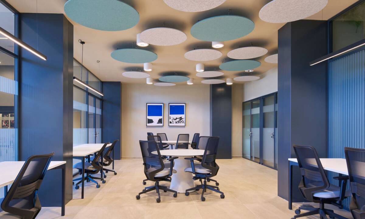 Zona coworking con paneles acústicos, sillas y mesas