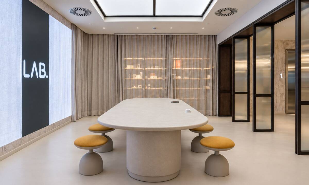 Zona LAB. con pantalla 4K de gran formato, mesa elevable y cortina que oculta zona de muestras