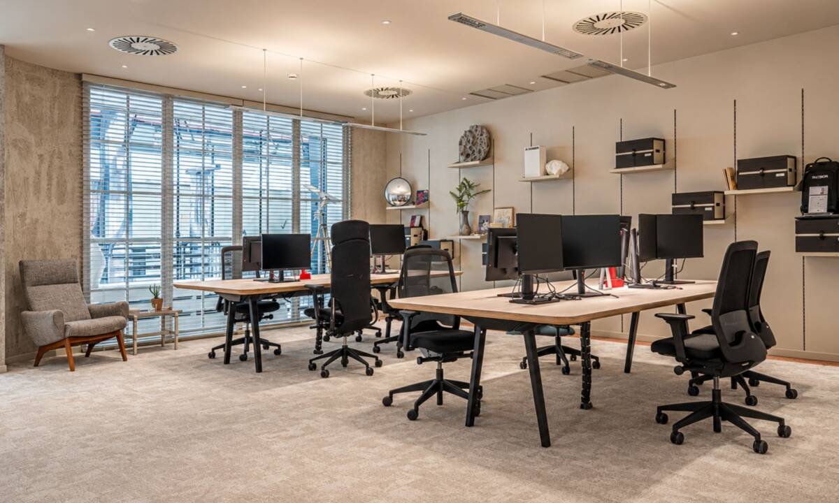 Espacio de trabajo con puestos operativos en oficina en tonos beige, terracota y mostaza