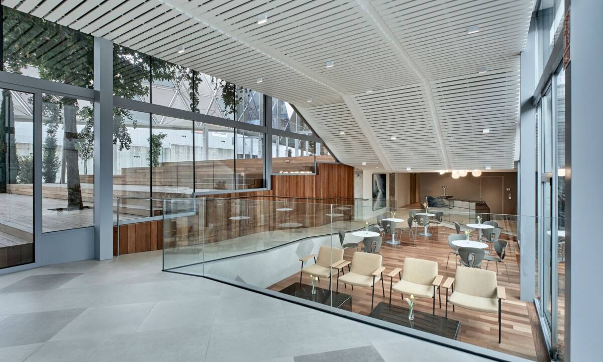 Zona de cafetería de eventos en espacio exterior de oficina con sillas y mesas