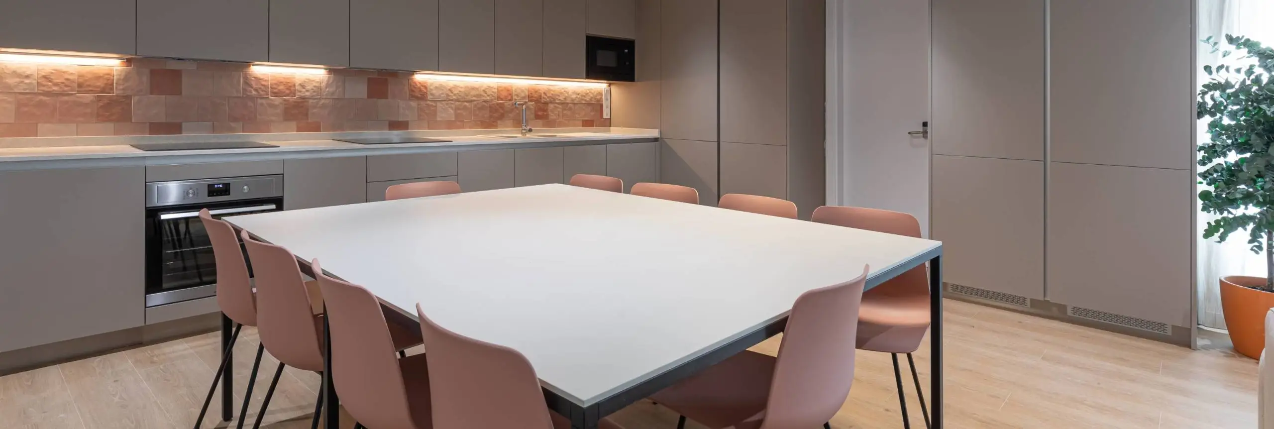 Espacio de cocina común con mobiliario en espacio coliving en Madrid