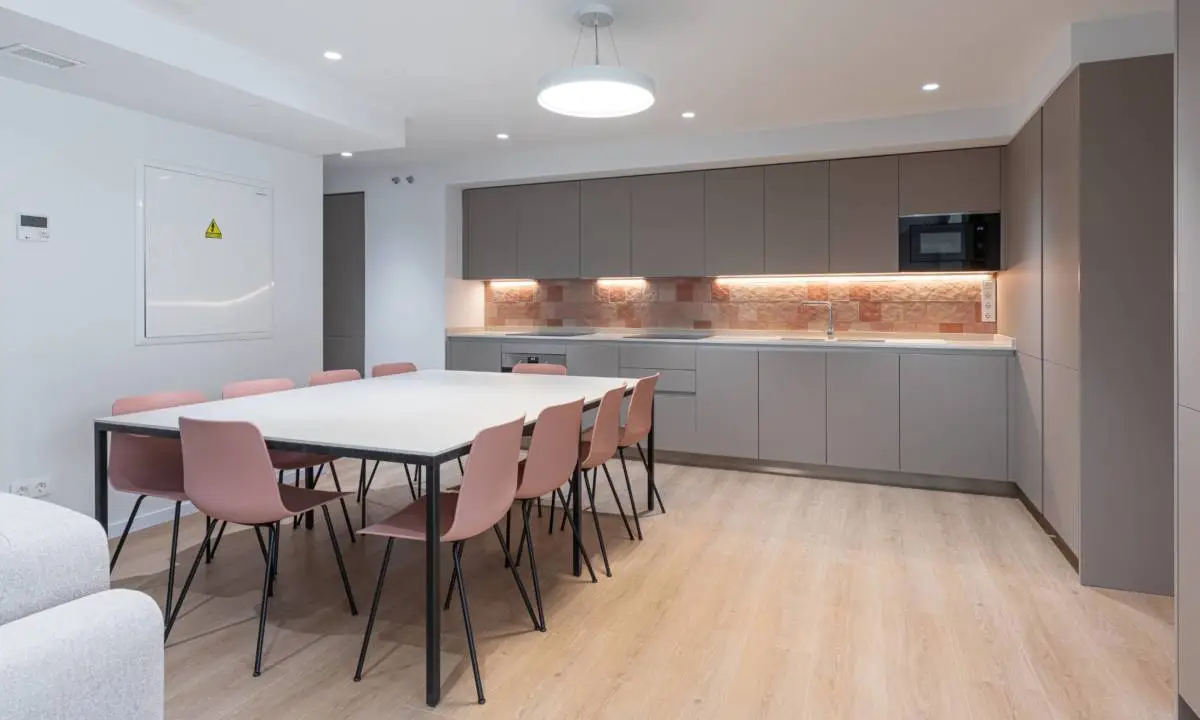 Cocina común con mesa de gran formato para espacio de comunidad en Coliving en Madrid