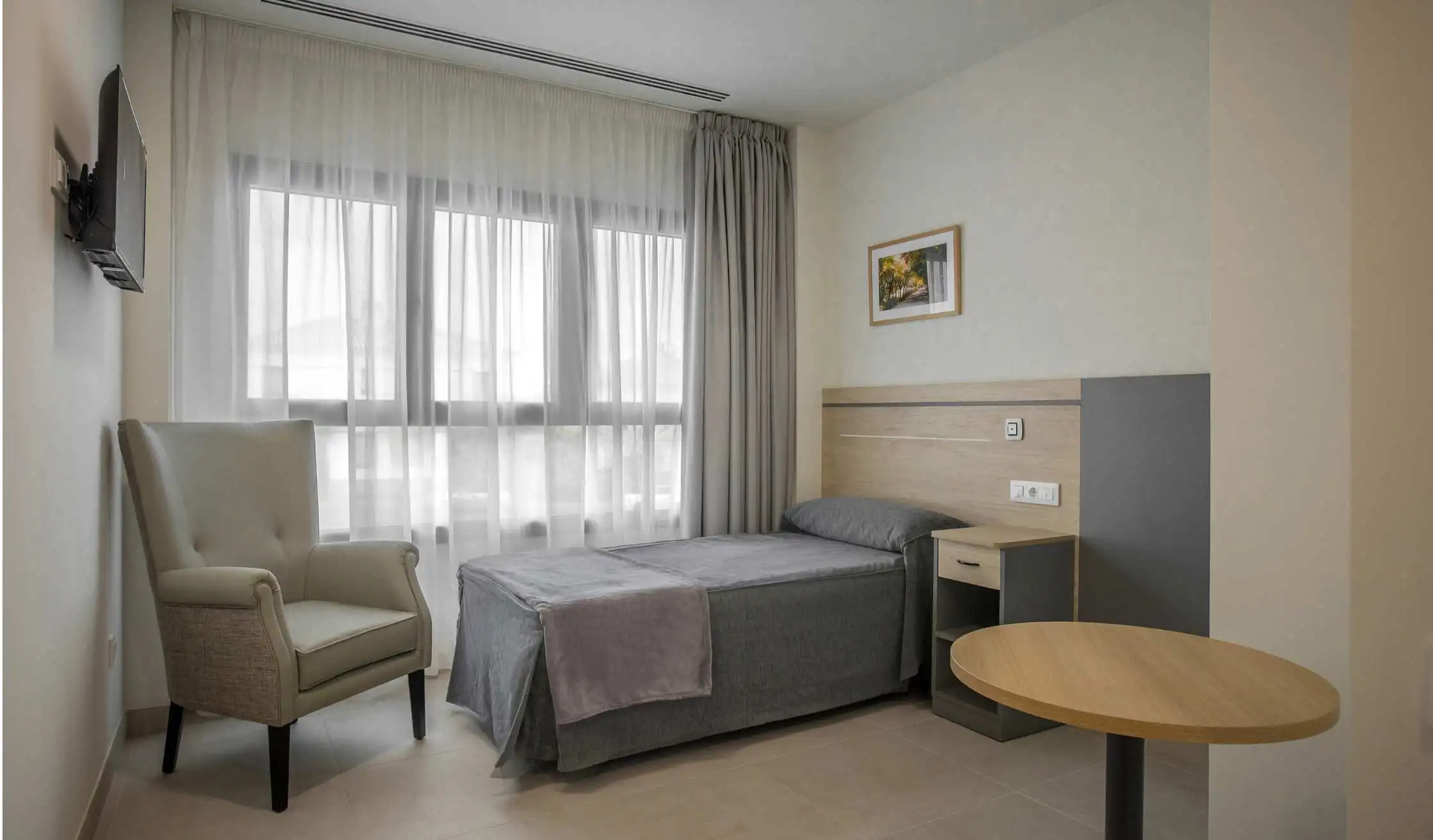 Cama en dormitorio individual de residencia Senior Living