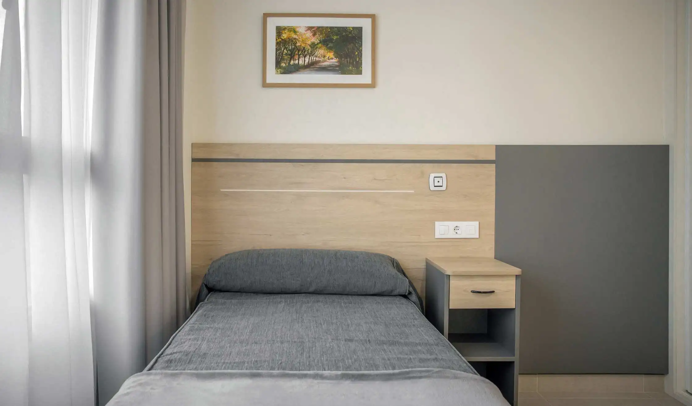 Cabecero de carpintería a medida y cama de residencia de mayores