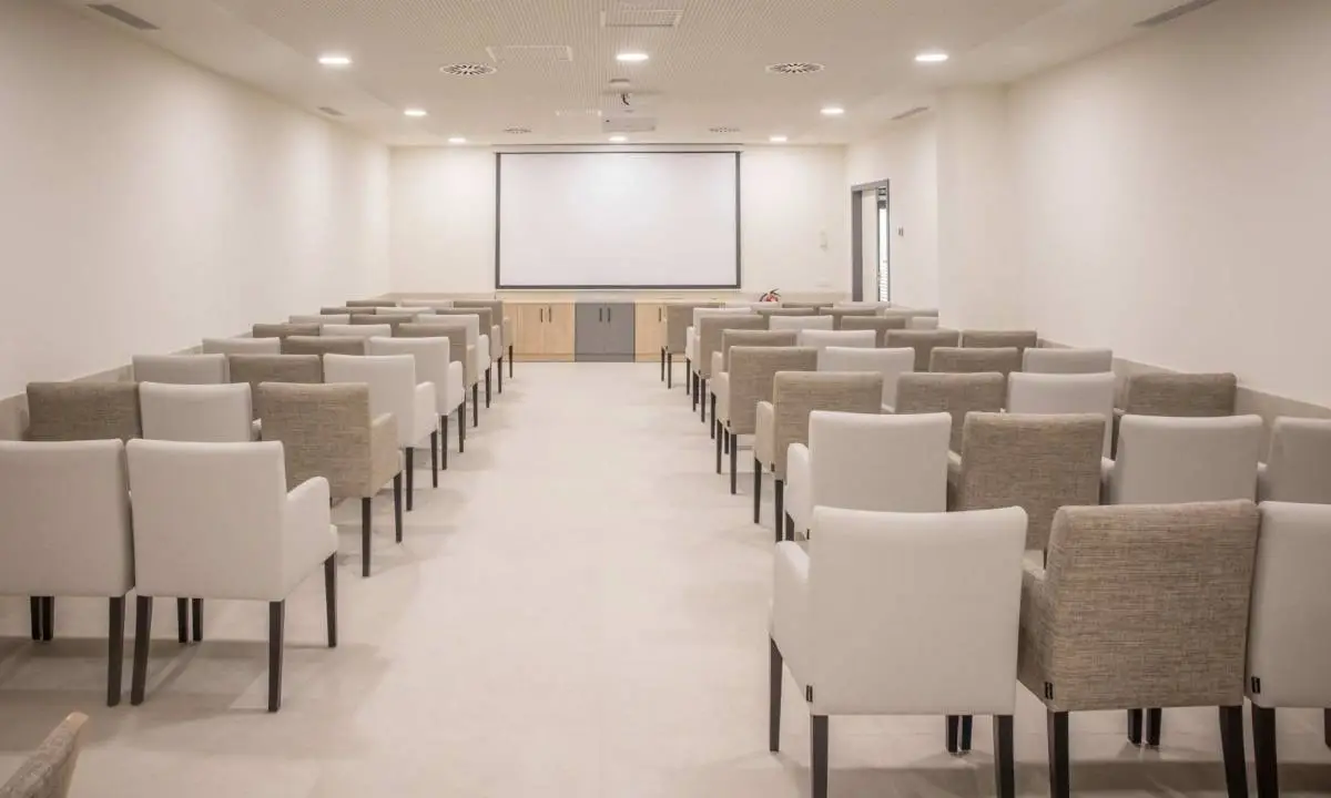 Sala de cine con butacas y proyector en residencia de mayores