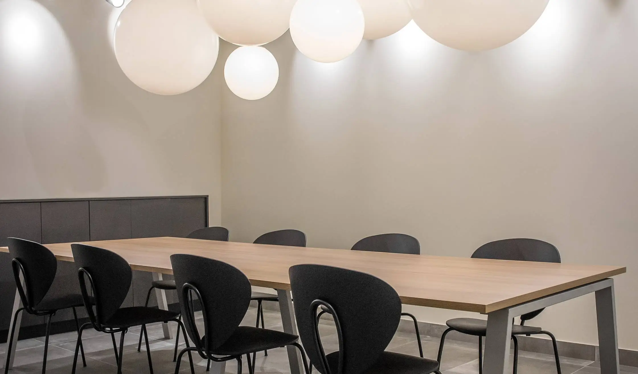 Mesa con sillas y luminaria en sala común