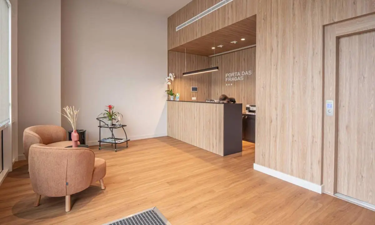 Recepción con carpintería de madera a medida, butacas color teja y demás mobiliario de hall de entrada
