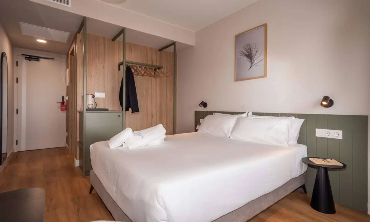 Cama de hotel en habitación totalmente equipada