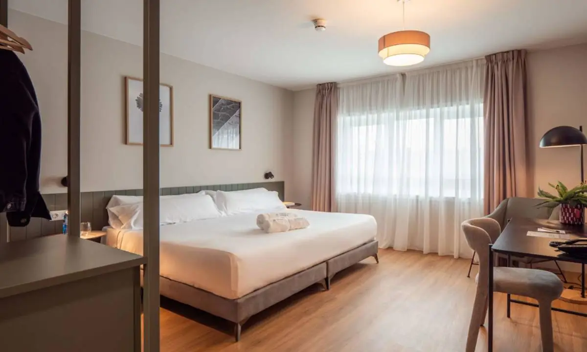 Dormitorio doble con cama, armario a medida y textiles