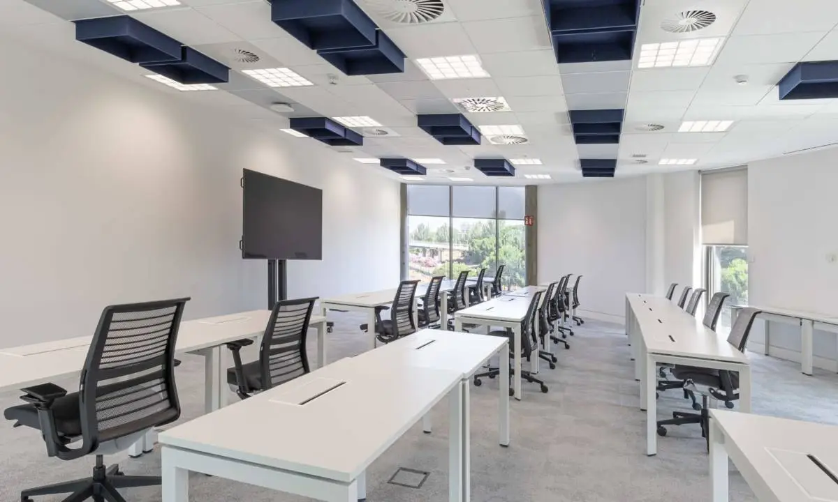 Puestos operativos en zona de trabajo abierta con mamparas y audiovisuales