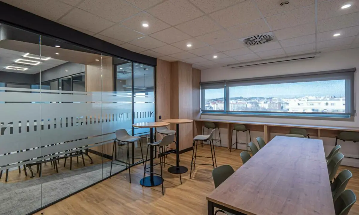 Office a medida para empleados con mesas y taburetes altos