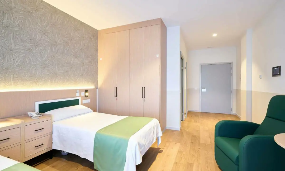 Habitación de residencia de mayores en tonos claros y verdes en León