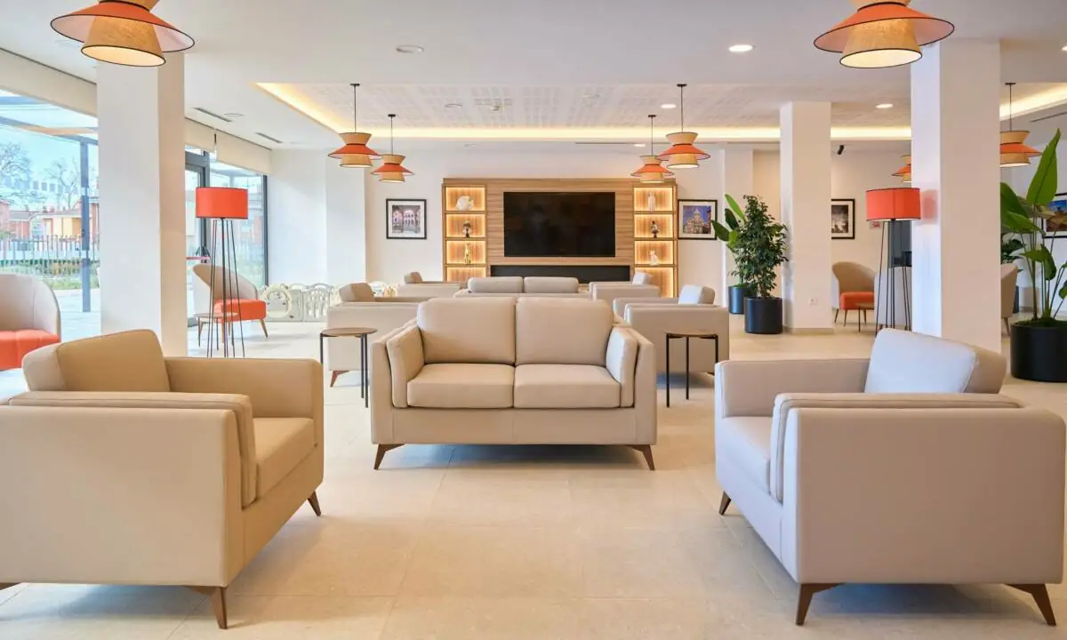 Sofás en tonos beige en salón común de residencia de mayores