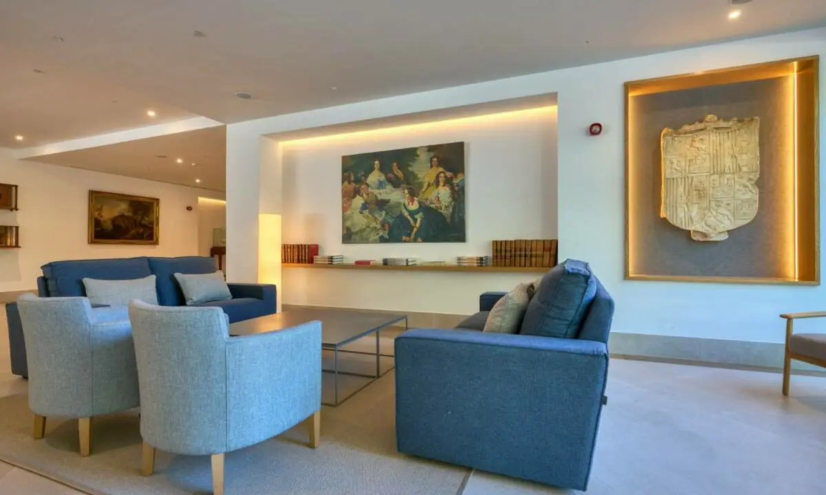 Salón común en hotel con sofás en tonos azules, decoración con motivos marineros y carpintería a medida