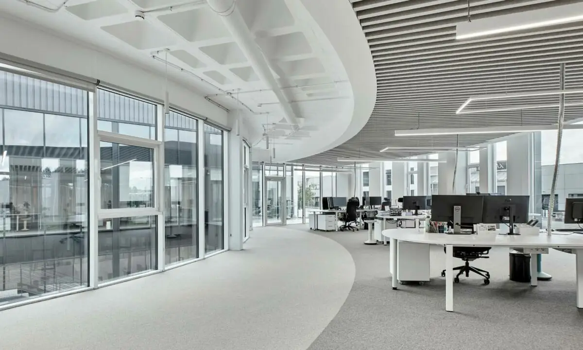Zona de trabajo con luz natural y puestos operativos en oficina en Galicia