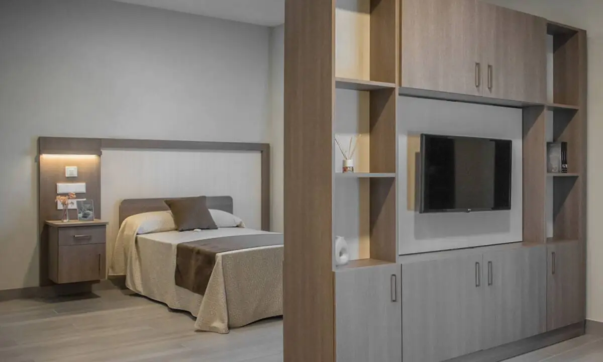 Mueble de carpintería a medida separador de ambiente en habitación con monitor de TV integrado