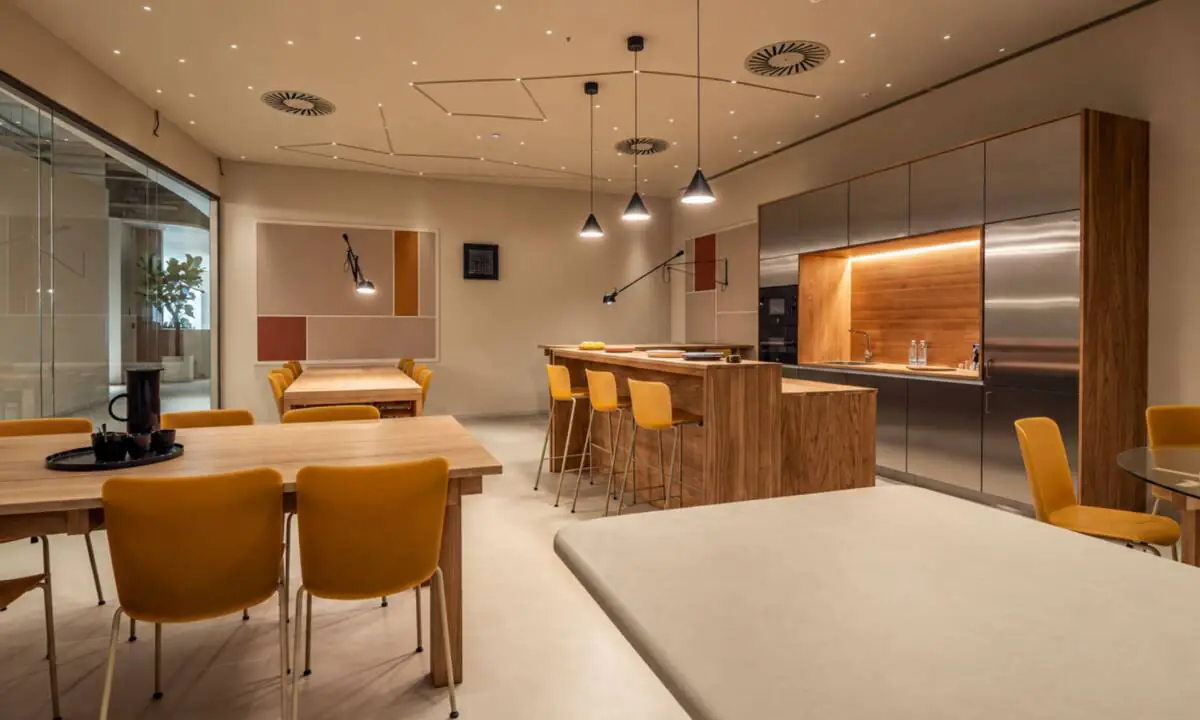 Zona de cantina en oficina con diferentes zonas de descanso, cocina y relax